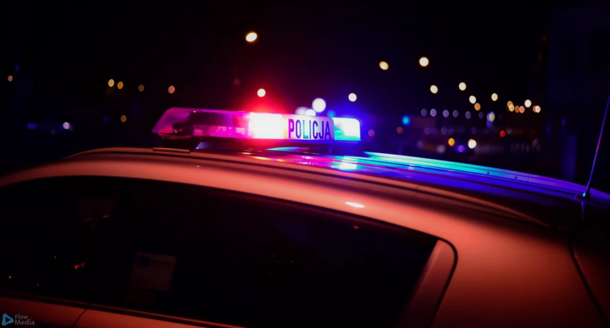 Zdjęcie przedstawia radiowóz policji z włączonymi sygnałami świetlnymi, pochodzi z archiwum KGP