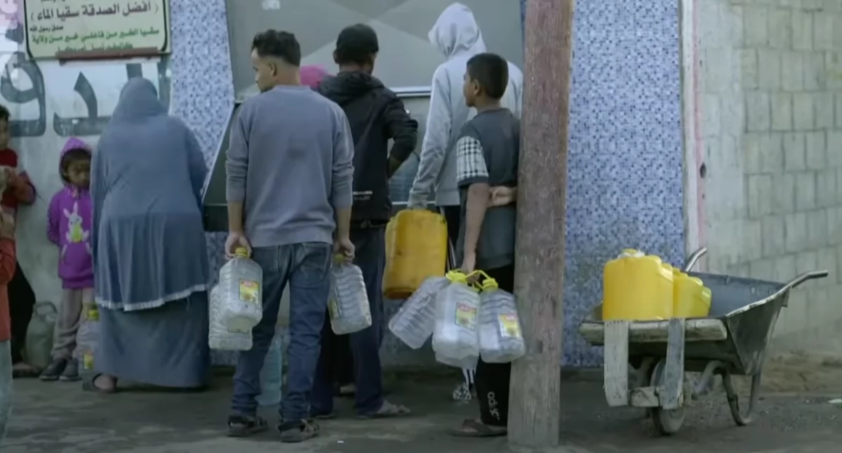 Mieszkańcy Strefy Gazy w oczekiwaniu na wydanie racji żywnościowych przekazywanych w ramach pomocy humanitarnej 