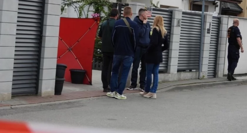 Policja przed domem jednorodzinnym w Raszynie w województwie mazowieckim — miejsce odkrycia ciała kobiety podczas interwencji 7 maja 2025, w tle taśma policyjna i radiowozy
